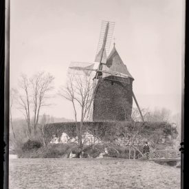 Landmark of the Outing: The ivy‑clad Moulin de Longchamp rises above its rustic bridge in the Bois de Boulogne.