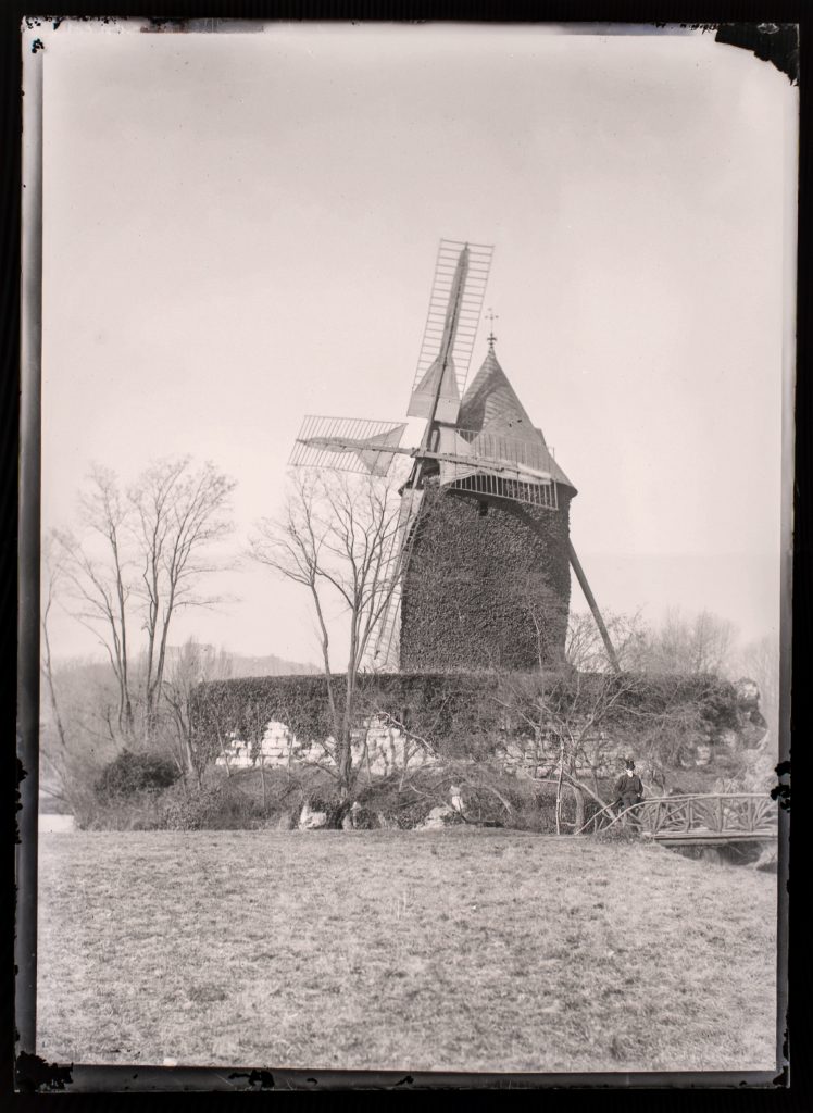Landmark of the Outing: The ivy‑clad Moulin de Longchamp rises above its rustic bridge in the Bois de Boulogne.